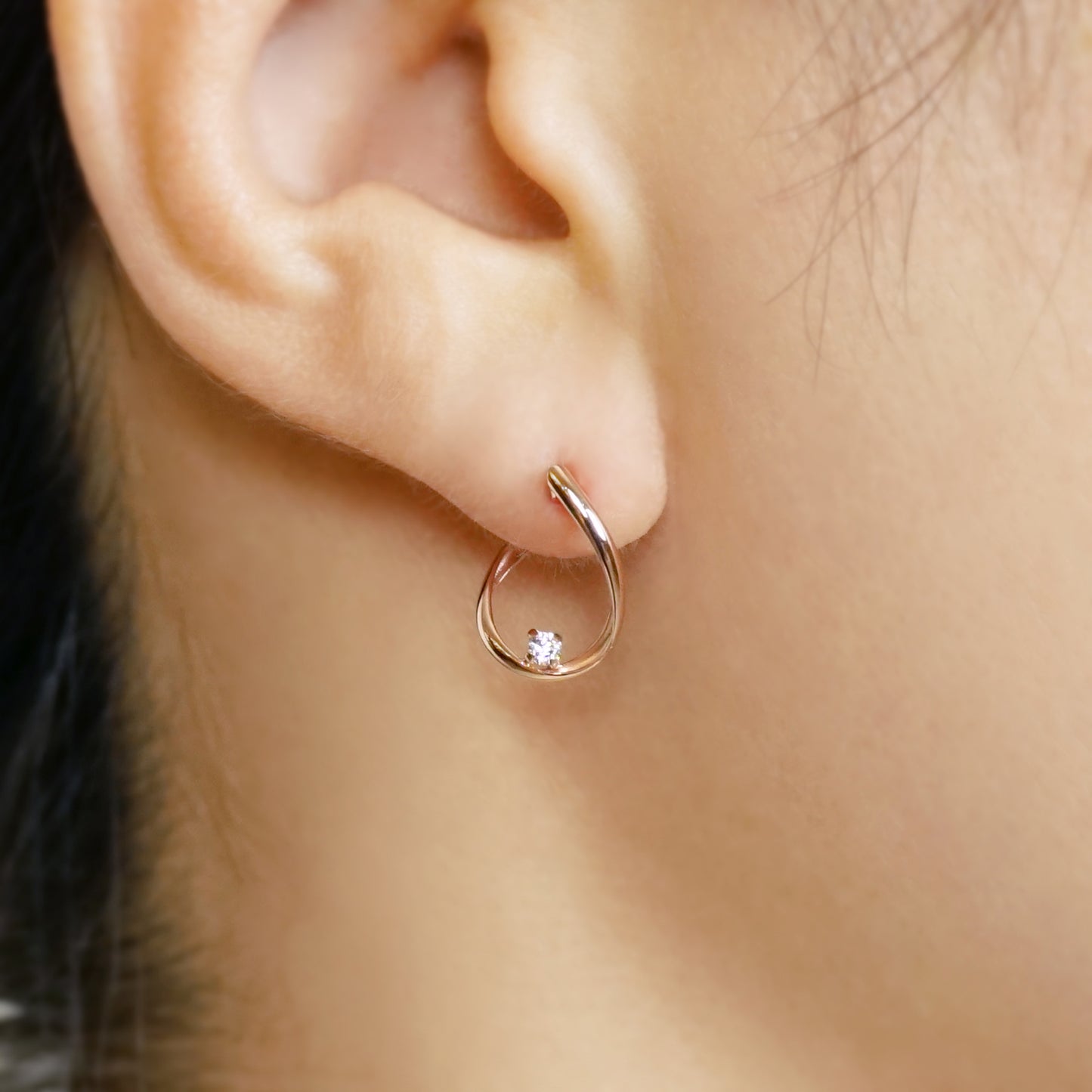 10K Cubic Zirconia Twisted Hoop Earrings (Rose Gold) - Model Image