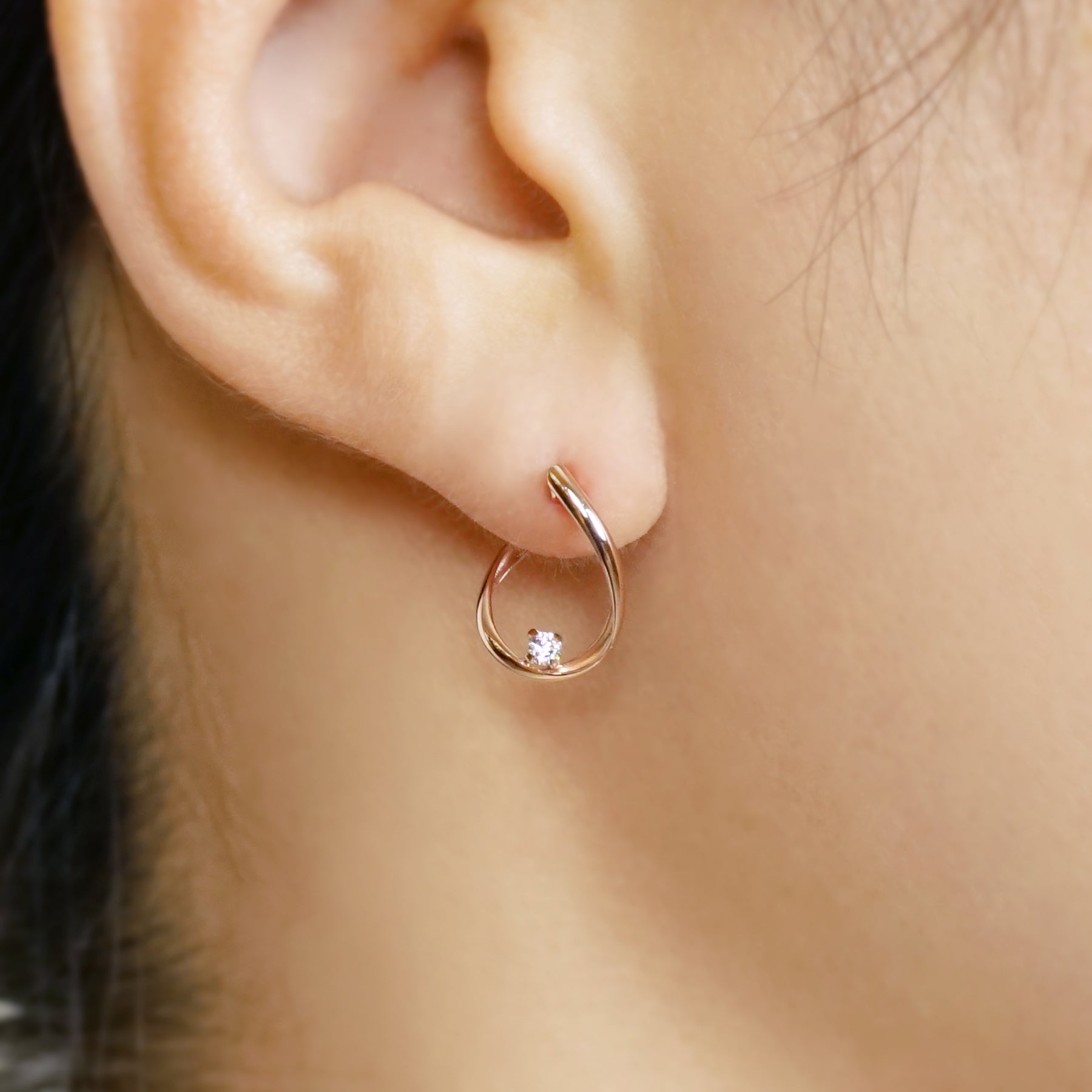 10K Cubic Zirconia Twisted Hoop Earrings (Rose Gold) - Model Image