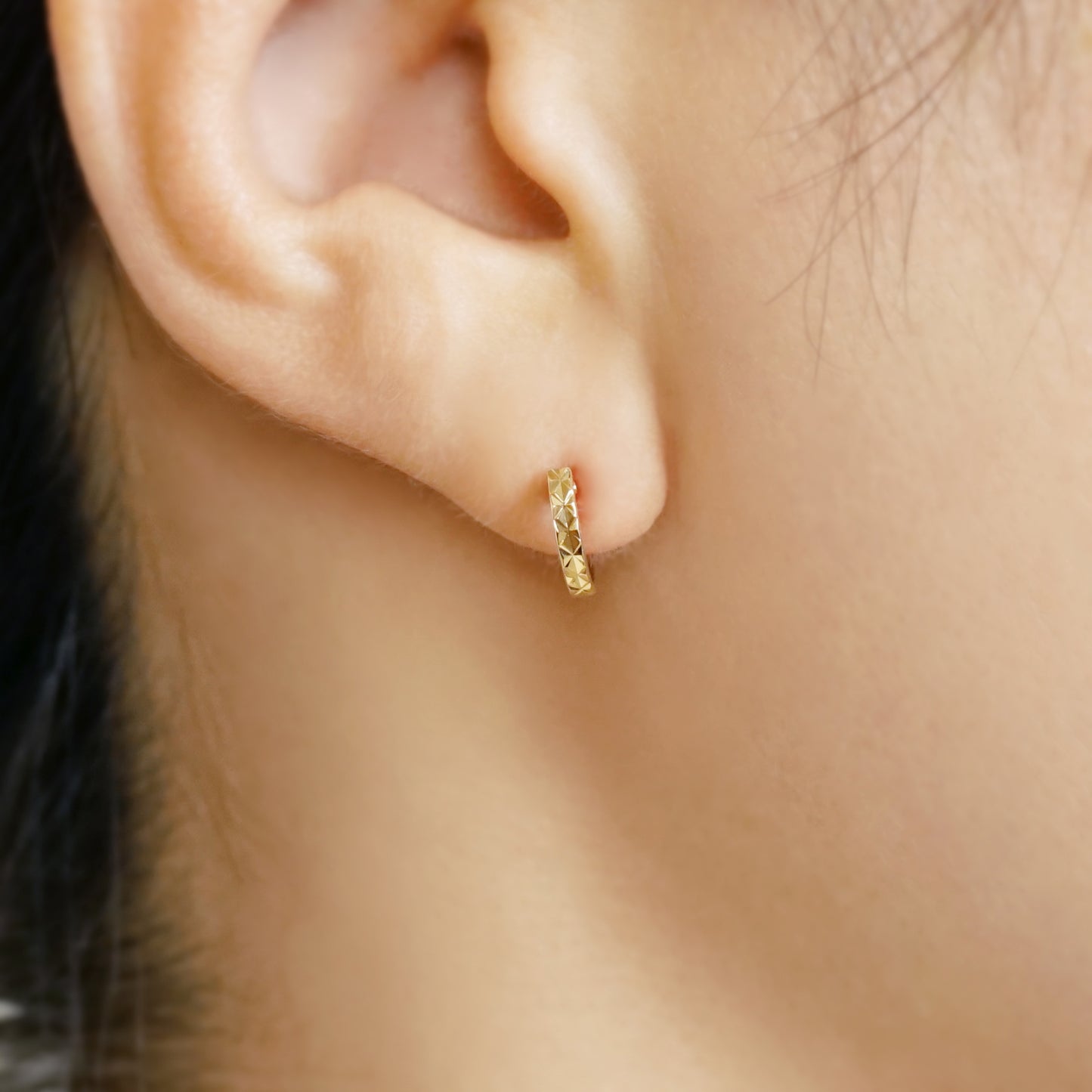 10K Faceted Mini Hoop Earrings (Yellow Gold) - Model Image