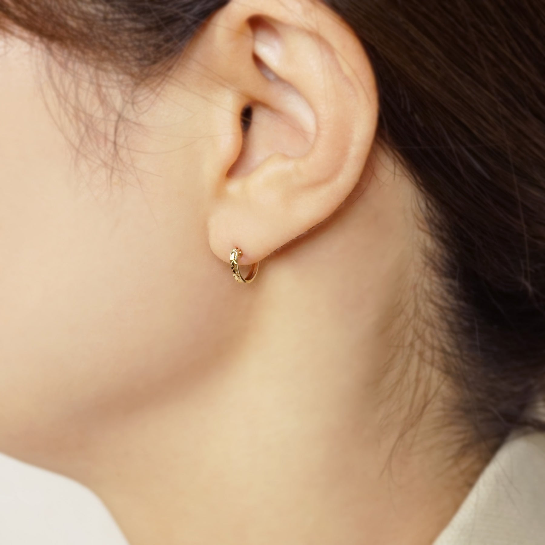 10K Faceted Mini Hoop Earrings (Yellow Gold) - Model Image