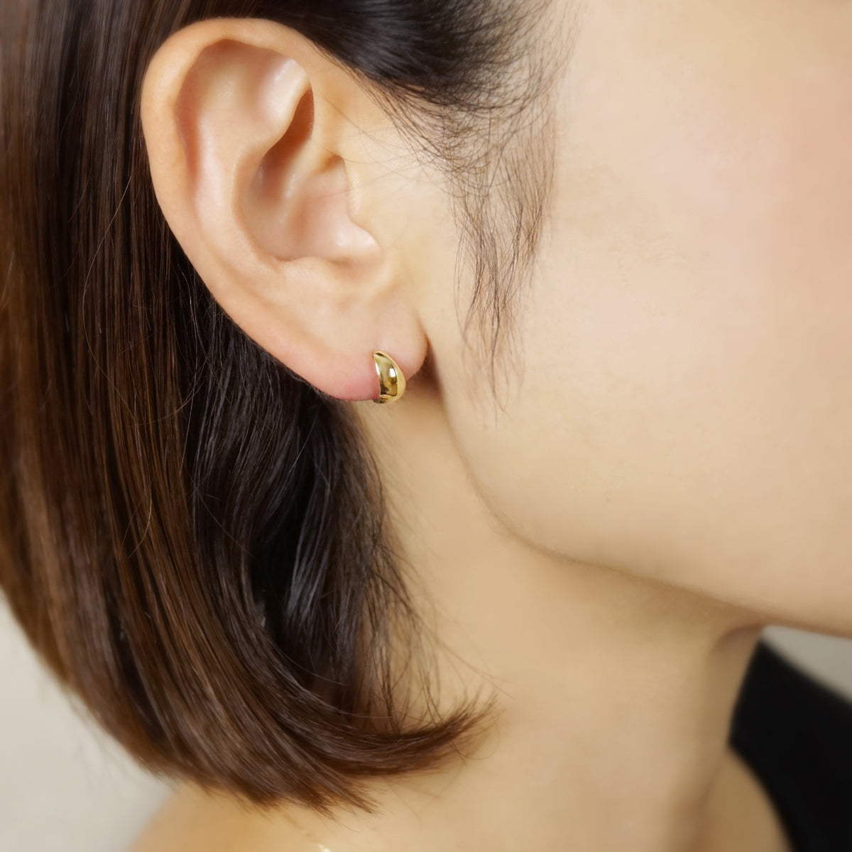 10K Plump Mini Hoop Earrings (Yellow Gold) - Model Image