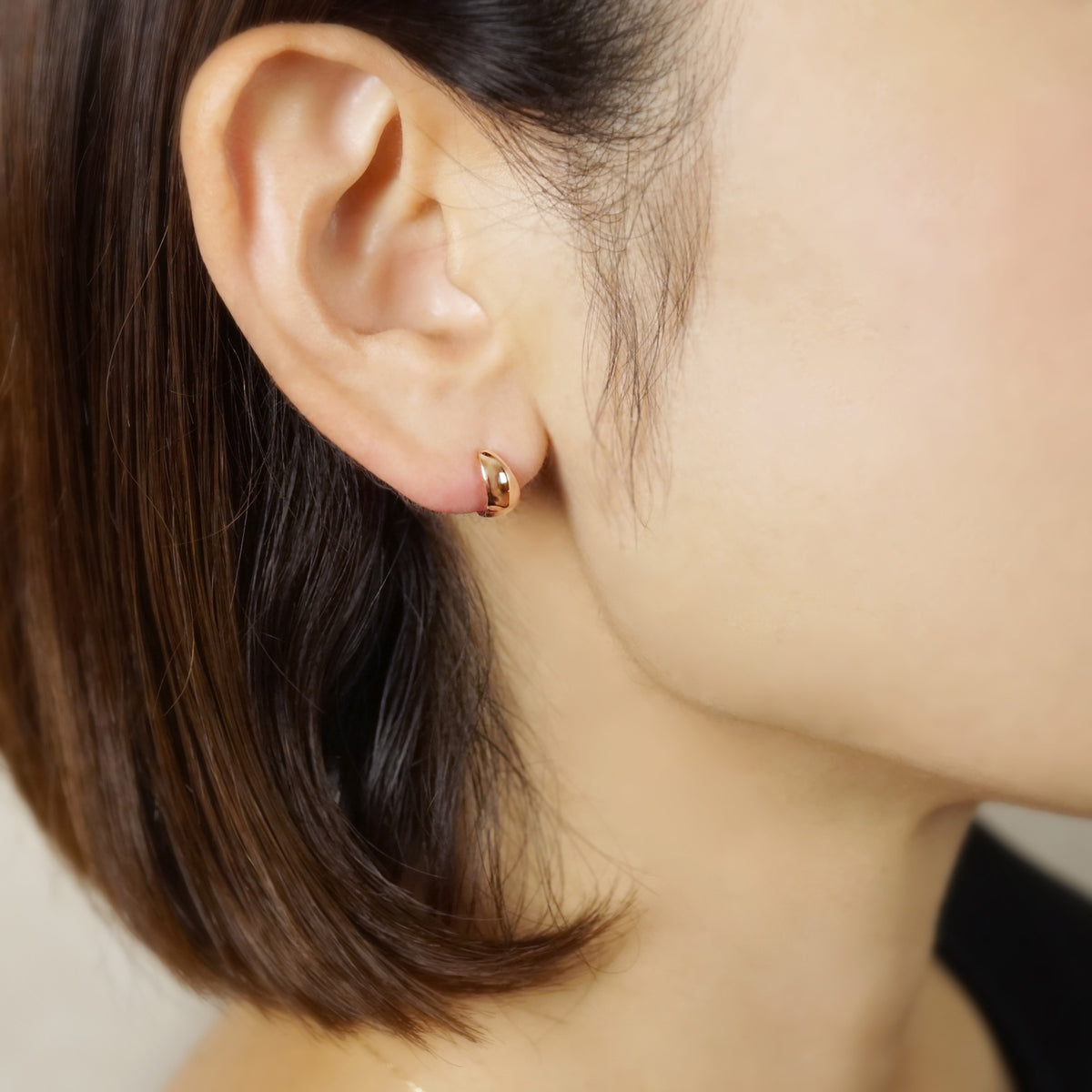 10K Plump Mini Hoop Earrings (Rose Gold) - Model Image