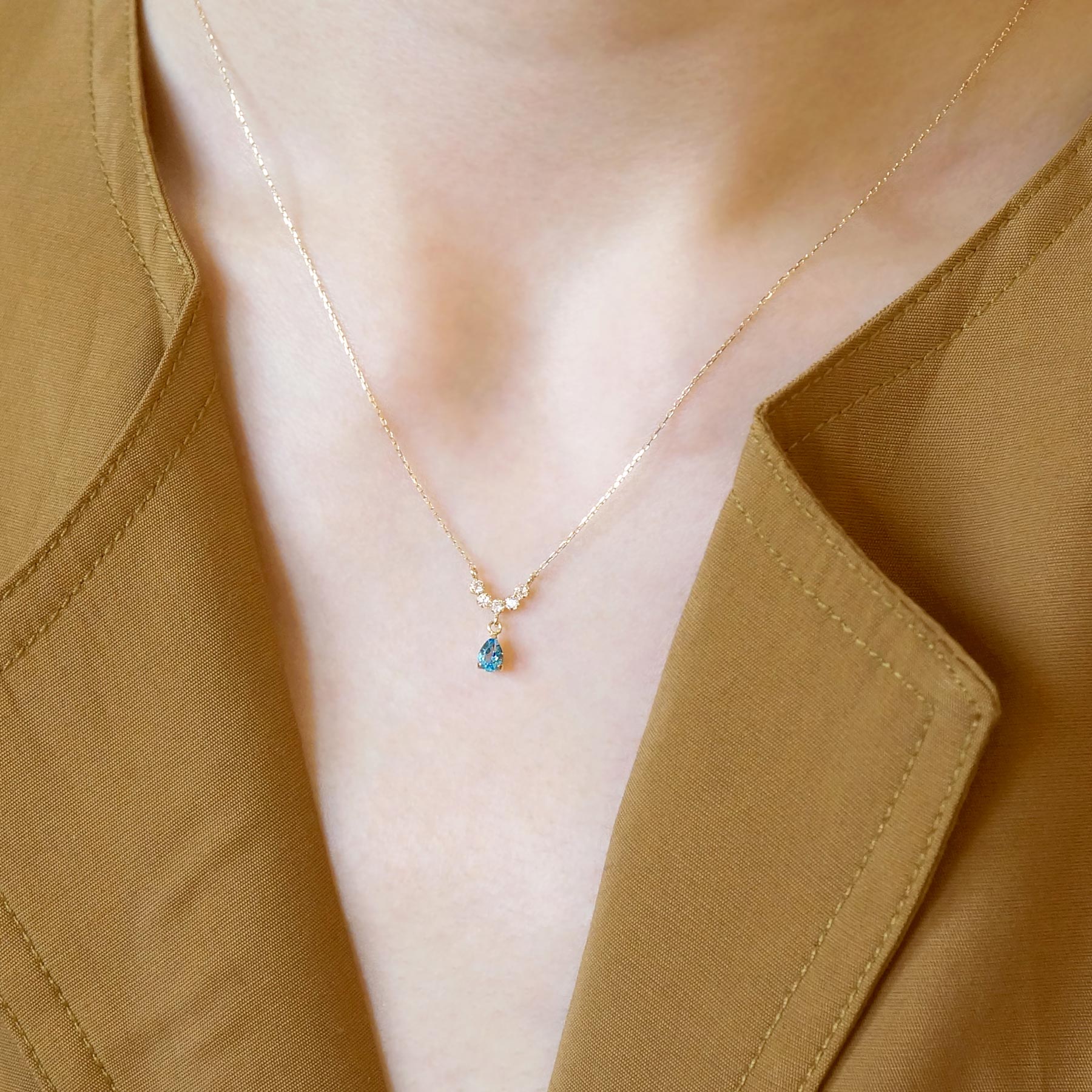 10K Yellow Gold Birthstone (Swiss Blue Topaz) Swinging Necklace - Model Image